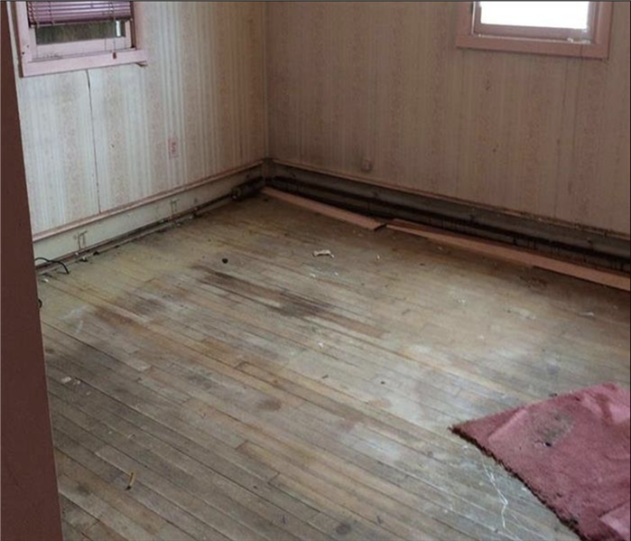 An old average sized empty water damaged room prepped for work.