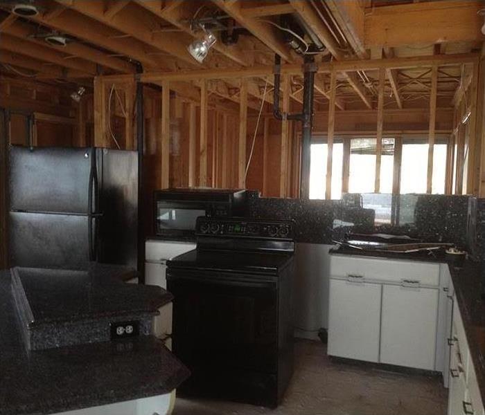 The same kitchen with all of the clutter removed along with every wall and ceiling completely gutted.