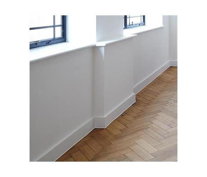 A brand new wall; white with white trim and new hardwood floors also.