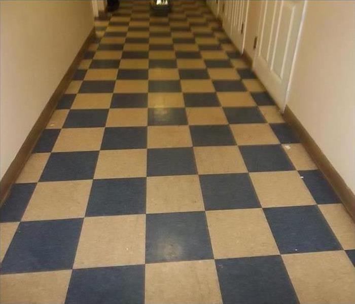 A blue and white checkered floor that looks old, scuffed, scratched, and faded.