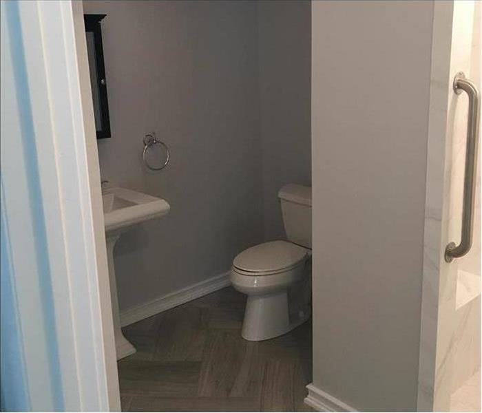 The same bathroom with brand new floors and walls painted a different color.