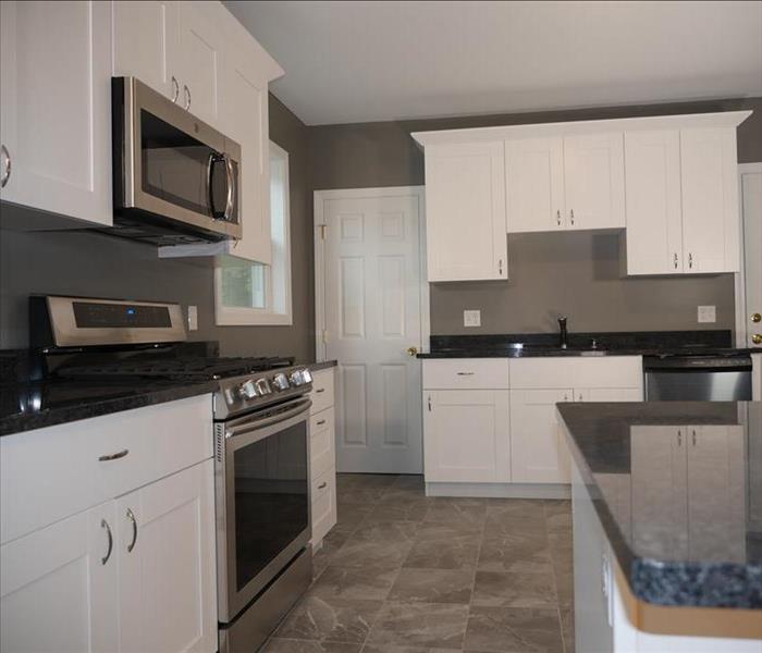 A new kitchen showcasing a new stove, microwave, and sink along with nice new cabinets & countertops.