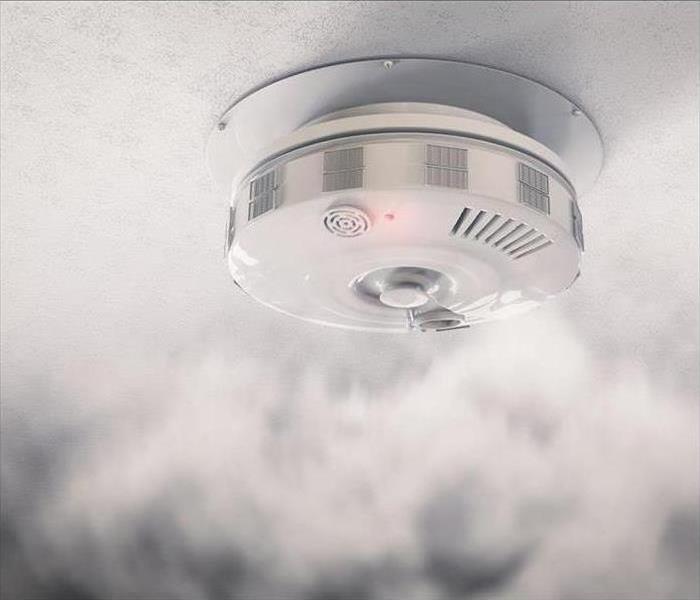A smoke detector is surrounded by smoke