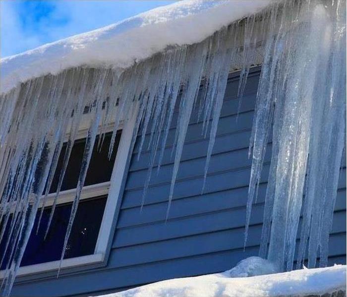 Icicles hang from the eaves of a house in winter