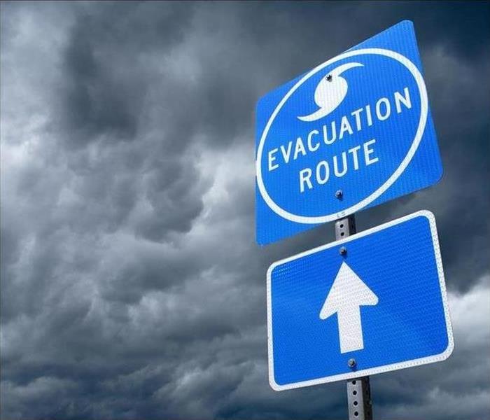 An evacuation sign in front of a stormy sky